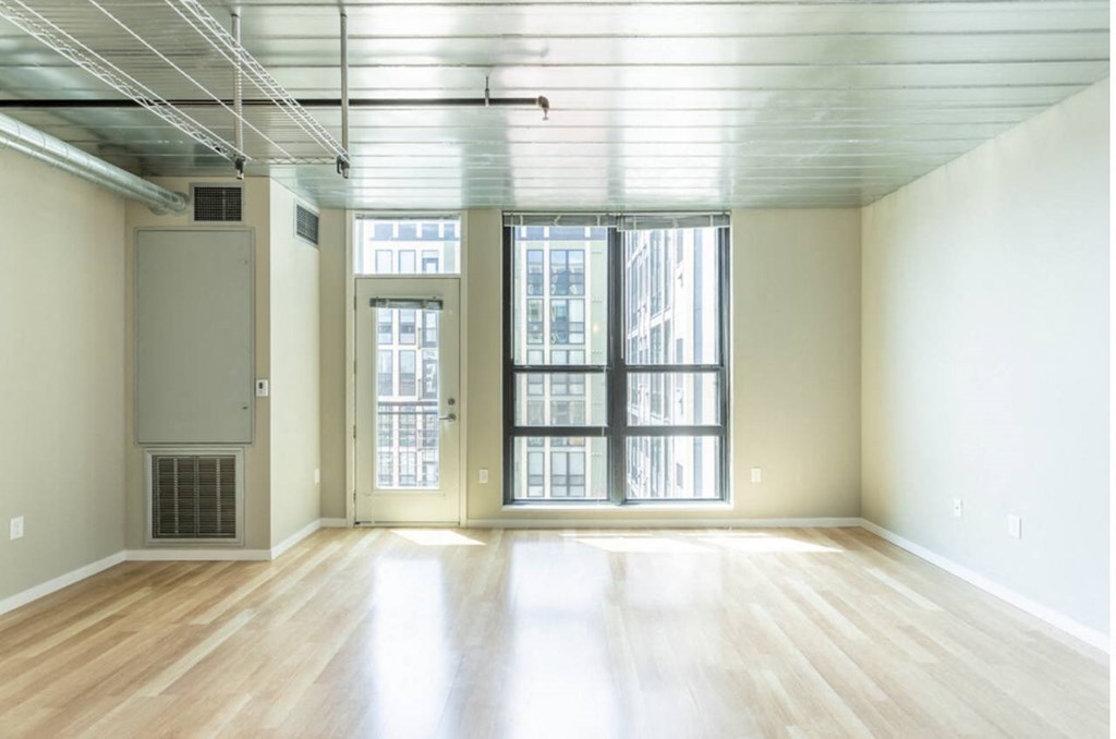 an empty living room with large windows and wood floors at Ann Arbor City Club, Ann Arbor, MI 48104